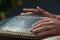 Close-up of a mans hand playing on modern musical instrument Hand pan or Vadjraghanta or metal tongue drumon, selective focus
