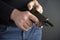 Close up of mans hand reloading gun, Man hold and loading ammunition his pistol on dark background
