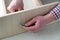 Close-up mans hands gather furniture drawer, tightens a screw into a hole