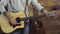 Close up mans hands tuning an acoustic guitar slow motion