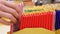 Close-up of many colorful chocolate bars standing in rows and a male buyer\\\'s hand takes one