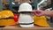 Close-up many safety helmets put on a cardboard box in warehouse store prepared for employees, red, white, and yellow hard helmets