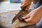 Close up manâ€™s hands are cutting roasted meat on a wooden chop