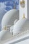 Close-up marble domes with golden pillar with Islamic sign on the topof Sheikh Zayed Grand Mosque with blue sky in the morning