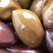 Close up marinated kalamata olives, product of Greece and Cyprus in oil as background. Square. Macro