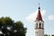 Close-up of maroon top of orthodox church bell tower with cross against sky and trees