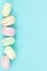 Close-up of marshmallow looks like macaroons cakes of different colors in blue background