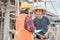 Close up of mason smiling at female constructor during discussion about building sketches