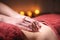 Close-up of masseur`s male hands doing abdominal massage to a female client in a dark office against the background of