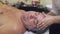 Close up of masseuse hands make healing massage of head to adult fat man.