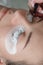 Close up of master marking places to sticking artificial lashes with pen on patches lying on lower eyelids of customer.