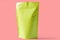 Close up of matt green paper doypack stand up packaging pouch with zipper on light pink background