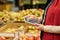 Close-up of mature female administrator of supermarket in red uniform