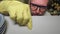 Close up of mature man`s face. He is concentrated on cleaning white shelf of cupboard in the kitchen using cotton swab