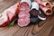 Close-up meat delicacies, thin slices of jamon and Italian sausage on a wooden board.