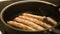 Close-up of meat sausages being fried in a frying pan. Concept. Close up view of sausages being fried in a pan. Pan with