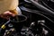 Close-up of mechanic adding oil with a funnel