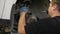 Close-up of a mechanic replacing brake pads on a car wheel at a service station.