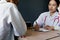 Close up medical doctor in white uniform gown coat interview and filling up an application form while consulting patient, medical