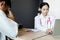 Close up medical doctor in white uniform gown coat interview and filling up an application form while consulting patient, medical