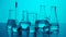 Close up medical glassware on neon background. Laboratory table with many different beakers and test tubes with liquid