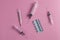 Close up of medical pills, needles of a syringe, thermomiter on pink table