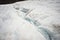 A close-up of a meltwater stream flows along a slope through a glacier fissure. Glaciers of Mount Elbrus. North Caucasus