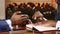 Close up of men hands during business meeting. Active gesturing, writing notes. Afro americans in suits on appointment