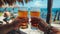 Close up of men hands holding cold craft beer glasses at outdoor beach cafe in summer ambiance