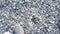 Close-up of men`s feet walking on stone beach. Media. Top view of stylish legs of man walking on stone beach. First