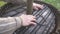 Close up men\'s hands assemble a wooden press for harvesting apple juice cider alcohol. Pressing fresh apples in bucket