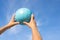 A close-up of mens hands with a volley ball against the blue sky.  Sport games