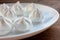 Close-up of meringue on a white plate. Marshmallows on wooden table background