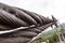 Close-up on a metal binding cable going in perspective to the bridge support with the texture of a summer sunny day. Reliability