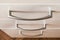 Close up of metal handle of a drawer. Modern wooden chest of drawers of light color. Concept of minimalist home furniture