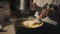 Close-up of a metal mechanical sieve sifting flour into a pan of dough, which is stirred by a woman.