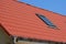 Close up on metal roof with attic skylight window and gutter.