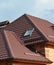 A close-up of a metal roofing waterproofing problem area with roof flashings, a complex roof with valleys, a skylight window, snow