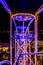 Close up of the metal structure of the wheel of fortune with a combination of purple blue en yellow lights