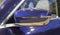 The close up of metallic blue rear view mirror of luxurious car.