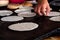 close up of a mexican woman preparing traditional handmade corn tortillas