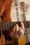 Close-up of mid adult man\'s fingers while playing guitar