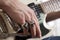 Close-up of mid adult man\'s fingers with rings playing guitar