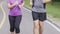 Close up middle aged couple jogging and running together at the park