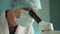 Close up of middle-aged doctor in medical mask and hat looking in microscope