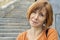 Close-up of a middle-aged redhead woman with an ironic smile