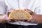 Close-up midsection of african american male baker showing cross section of baked bread