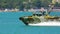 Close-up military landing speed boat with weapons quickly floats on blue surface of sea leaving traces of foam