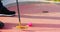 Close-up of a miniature golf putter and a pink golf ball