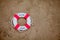 Close-up Of Miniature Lifebuoy Dig In The Sand At Beach